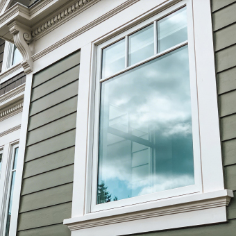 Professional painter applying white paint to an interior wall with a roller.