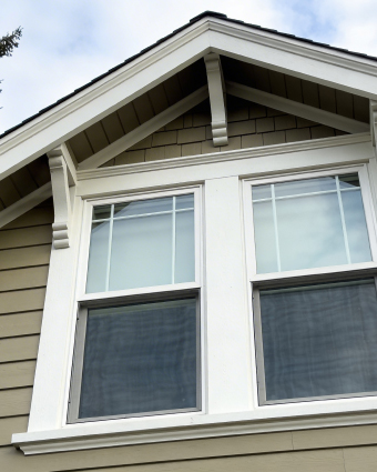Professional painter applying fresh white paint to an interior wall with a roller.